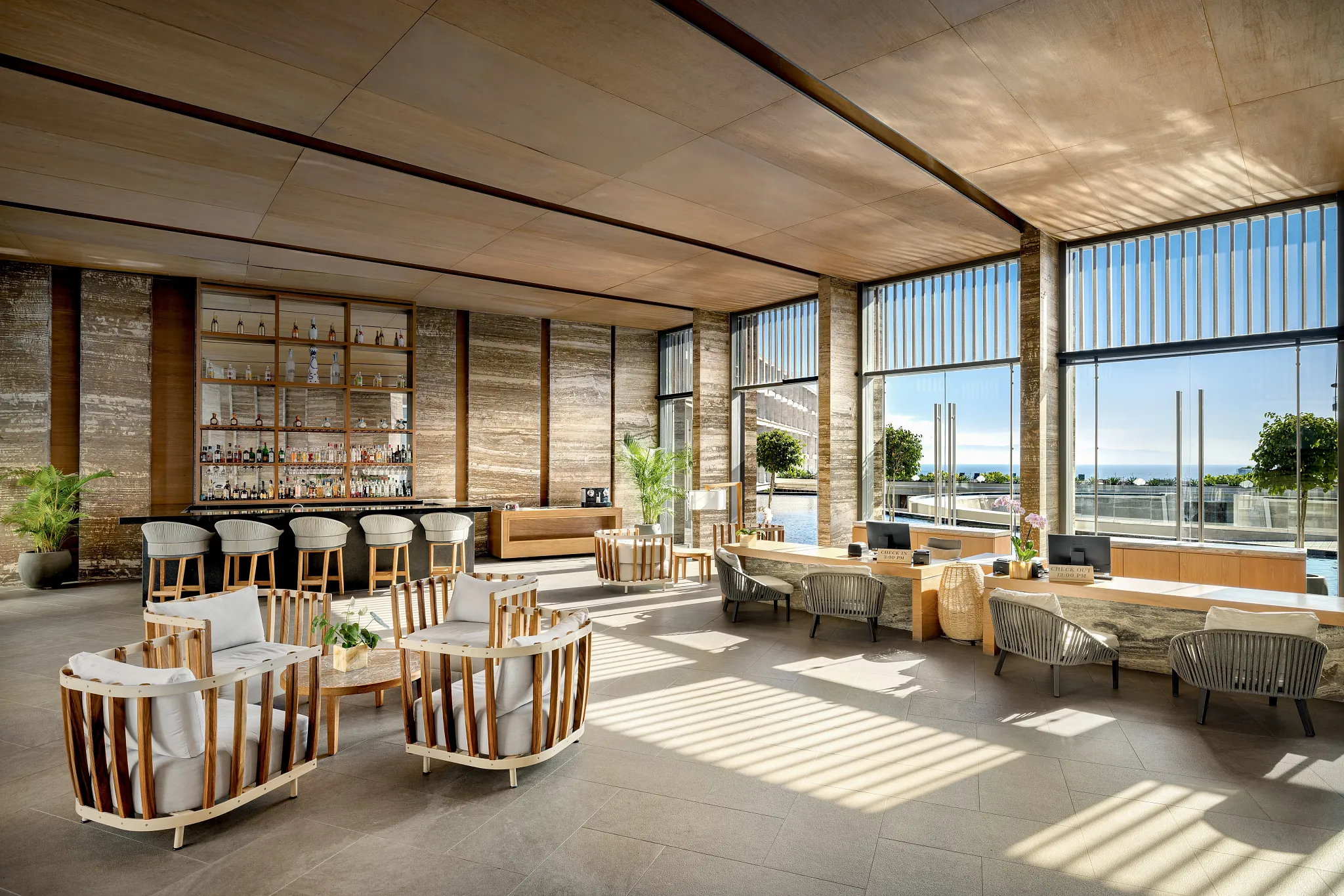 Modern lobby lounge with bar, seating, and ocean views at Dreams Bahia Mita.