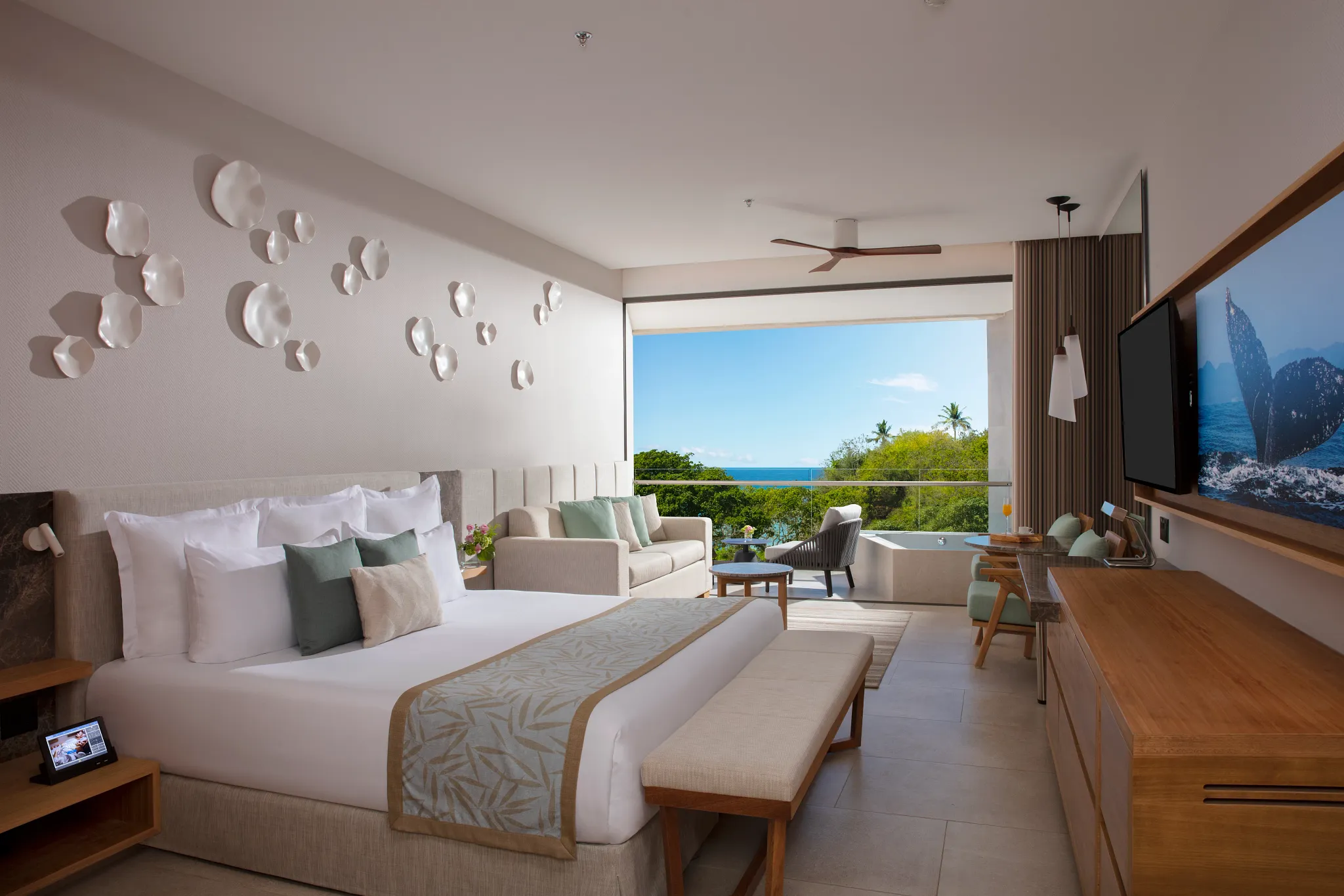 Preferred Club Junior Suite Partial Ocean View with king bed and seating area at Dreams Bahia Mita Resort.
