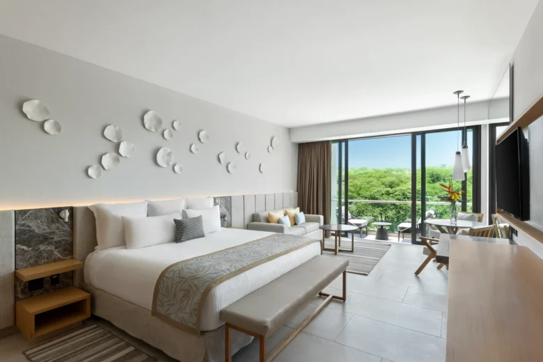 Preferred Club Junior Suite Tropical View with king bed and seating area at Dreams Bahia Mita Resort.